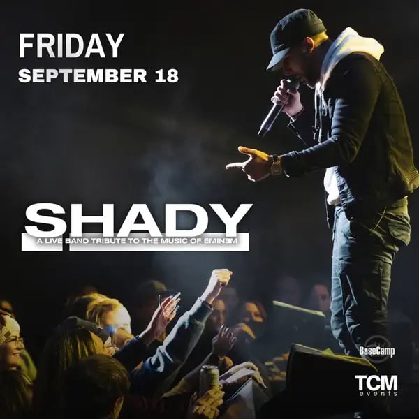 Eminem tribute artist performing on stage with an audience cheering.
